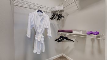 a walk in closet with a robe and hangers  at Mason, McKinney, Texas